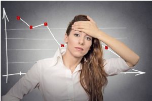 Woman holding head in front of a graph